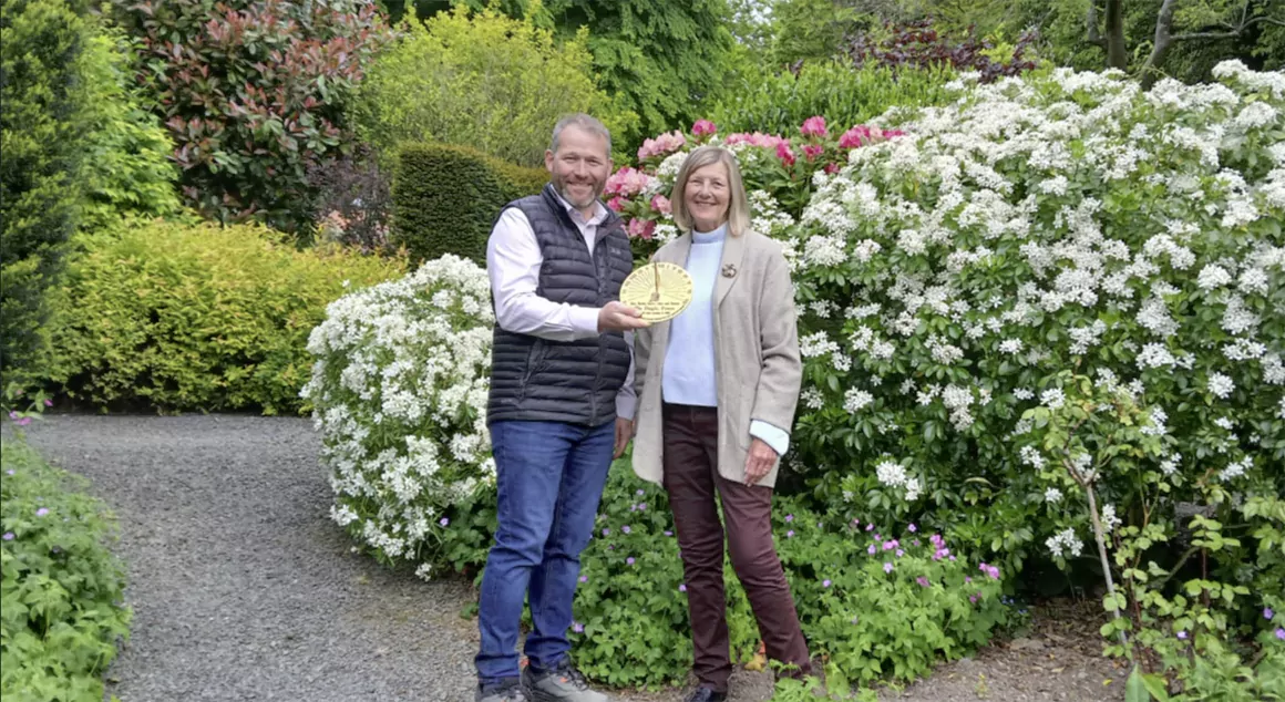 Susan Paynton presenting the sundial to Duncan Hamer of the Dingle Nurseries and Garden